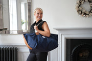 A lady carrying risdon and risdon canvas and leather market bag made in england.