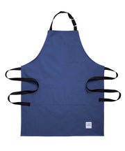 Handcrafted, blue canvas apron with black straps; made in Britain.