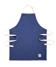 Handcrafted, blue canvas apron with white straps; made in Britain.