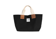 A black handcrafted leather and canvas mini market bag