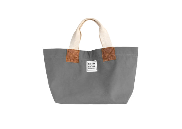 A grey handcrafted leather and canvas mini market bag