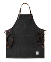 Handcrafted, black, denim apron; made in Britain with pockets and removable leather straps.