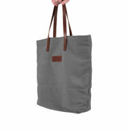 A handcrafted grey canvas totebag with leather straps.