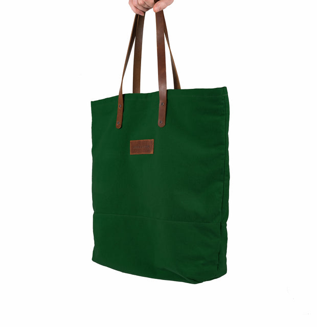 A handcrafted green canvas totebag with leather straps.