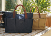 A tan canvas gardeners bag with leather handles. Also another bag with denim instead of canvas