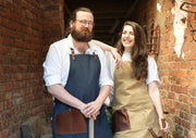 Gardeners wearing handcrafted aprons that are made in Britain with removable, leather straps and pocket.