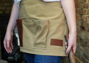 Gardener wearing handcrafted, khaki canvas waist (half)-apron; made in Britain with leather pocket.