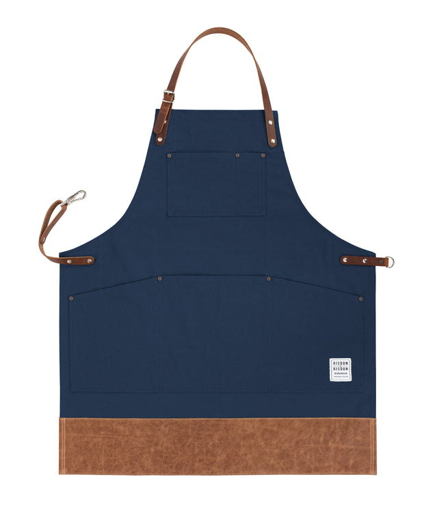 Handcrafted, navy blue canvas apron; made in Britain with pockets and leather trim and straps.