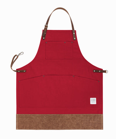 Handcrafted, red canvas apron; made in Britain with pockets and leather trim and straps.