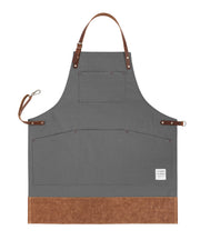 Handcrafted, heritage grey canvas apron; made in Britain with pockets and leather trim and straps.