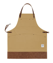 Handcrafted, tan canvas apron; made in Britain with pockets and leather trim and straps.