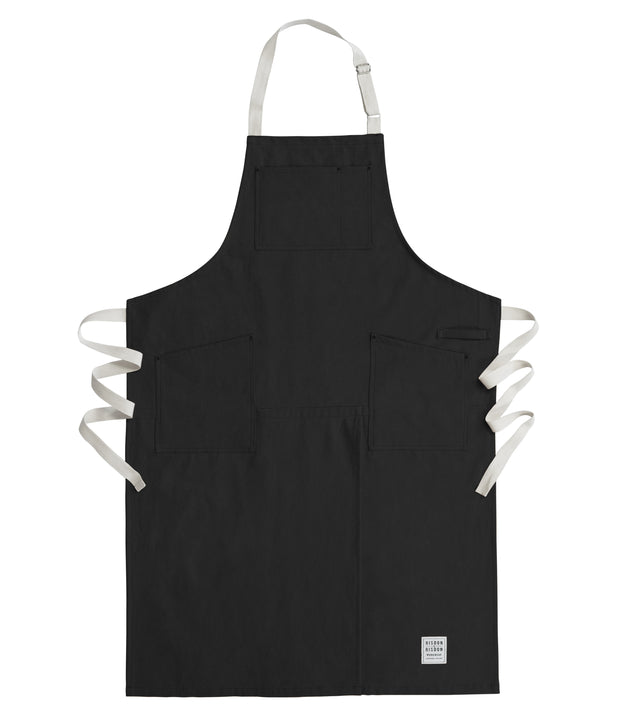 Handcrafted, black canvas apron with white straps; made in Britain.