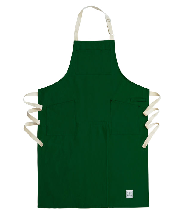 Handcrafted, green canvas apron with white straps; made in Britain.