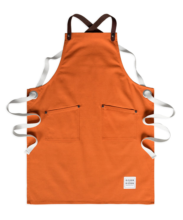 Children's handcrafted orange canvas apron with removable leather straps: made in Britain.