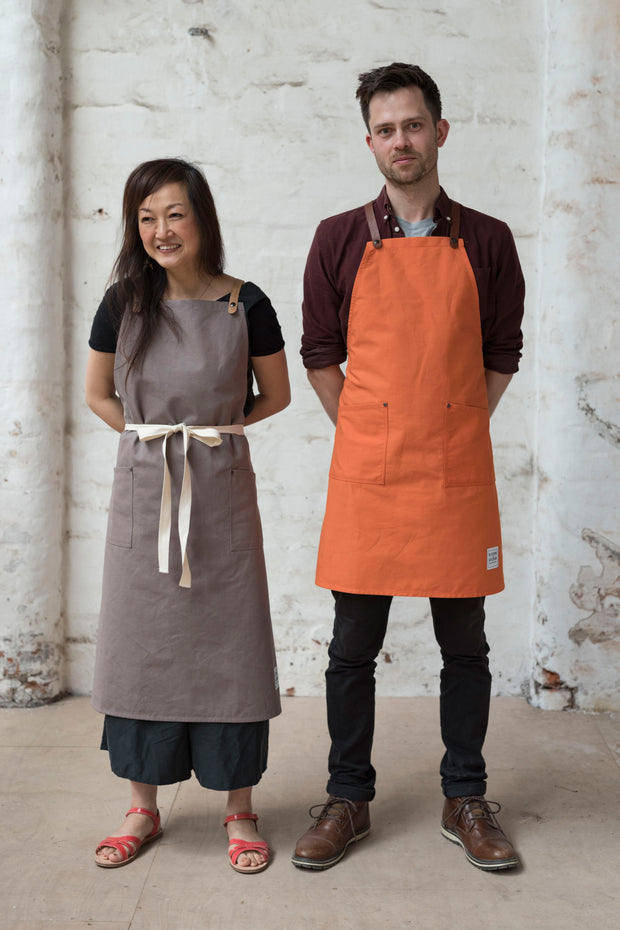 two people wearing handcrafted canvas apron with removable corck straps