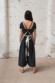 A person wearing a handcrafted canvas apron with removable corck straps 