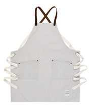 A handcrafted canvas apron with removable leather straps 