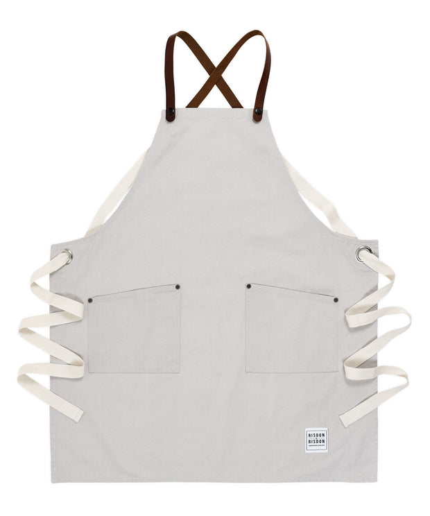A handcrafted canvas apron with removable leather straps