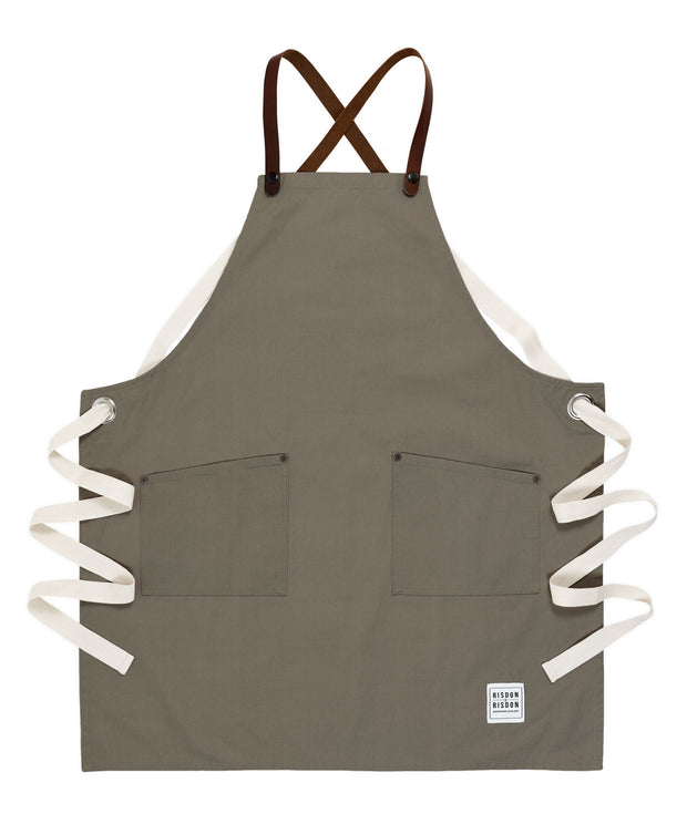 A handcrafted canvas apron with removable leather straps
