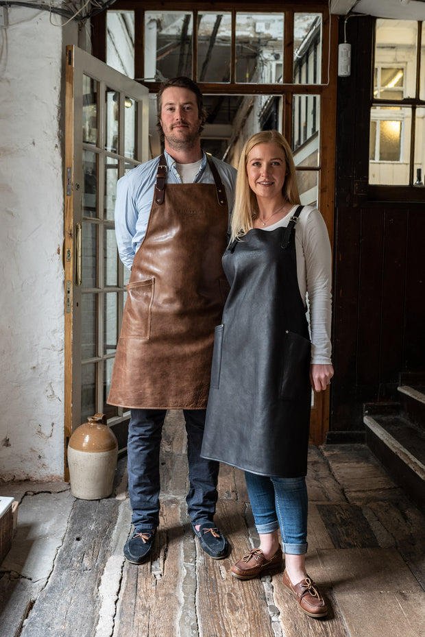 Two people wearing an all leather handcrafted apron with removeable straps. made in britan