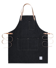 Handcrafted, black denim apron; made in Britain with pockets and removable cork straps.